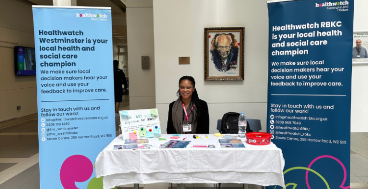 Picture of healthwatch staff member at chelsea and westminster hospital with banners explaining the role of healthwatch.