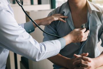 A doctor doing a health check up on a patient using a stethoscope 