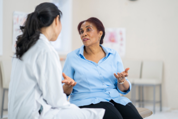 A female medical professional speaking to a female patient.