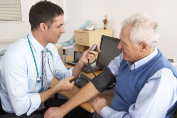 Doctor Taking Senior Man's Blood Pressure.